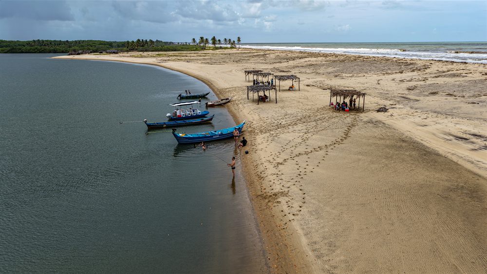Barcos ancorados e barracas de palha na beira da praia